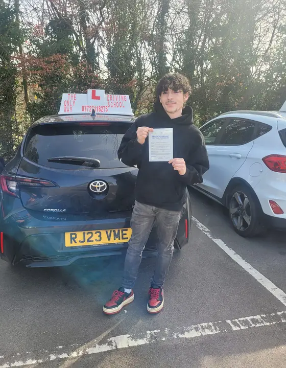 Student holding a pass certificate after their driving test